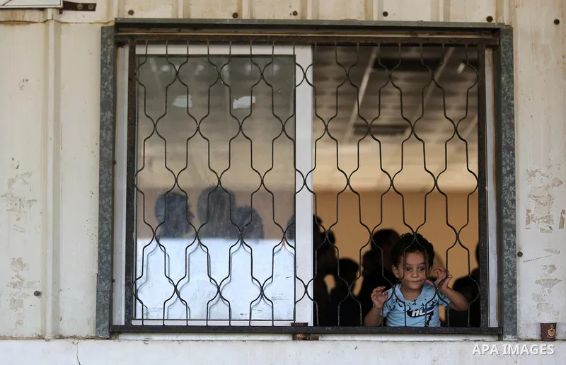 Palestinians wait for travel permits to cross into Egypt through the Rafah border crossing in Khan Yunis in the southern Gaza Strip on July 18, 2018. Photo by Ashraf Amra