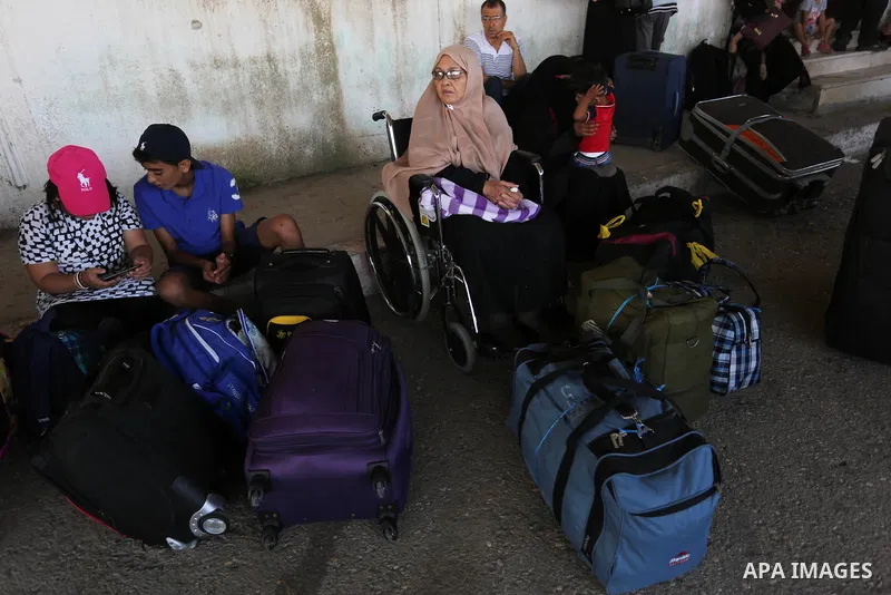 Palestinians wait for travel permits to cross into Egypt through the Rafah border crossing in Khan Yunis in the southern Gaza Strip on July 18, 2018. Photo by Ashraf Amra