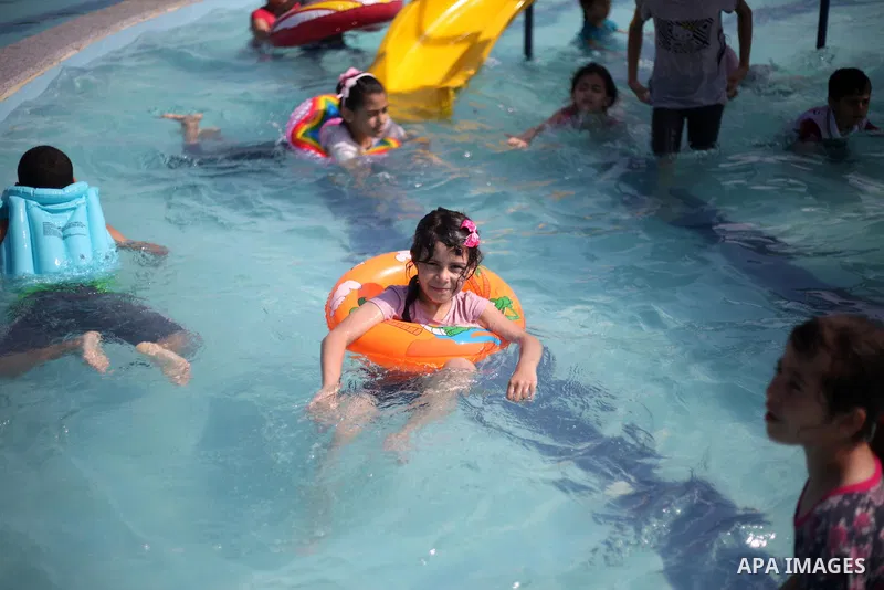 Palestinian children swim in a pool at an amusement park during the summer holiday, in Gaza city on July 19, 2018. Photo by Mahmoud Ajour