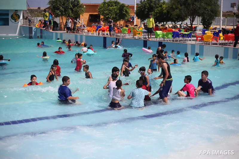 Palestinian children swim in a pool at an amusement park during the summer holiday, in Gaza city on July 19, 2018. Photo by Mahmoud Ajour