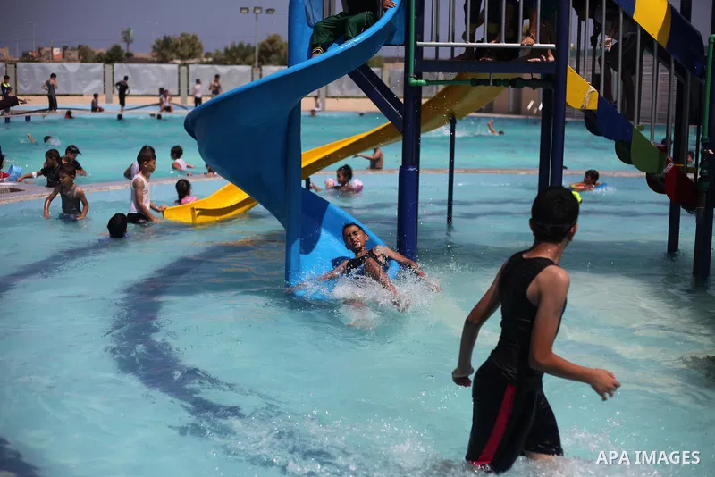 Palestinian children swim in a pool at an amusement park during the summer holiday, in Gaza city on July 19, 2018. Photo by Mahmoud Ajour