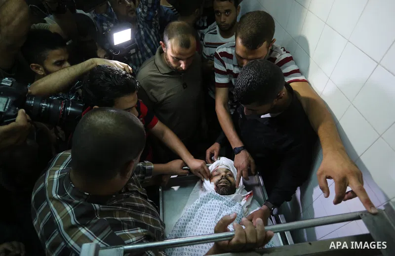 Relatives of Palestinian Abdul Karim Radwan, who was killed in an Israeli air strike, mourn over his body at a hospital in Rafah in the southern of Gaza Strip July 19, 2018. Photo by Ashraf Amra