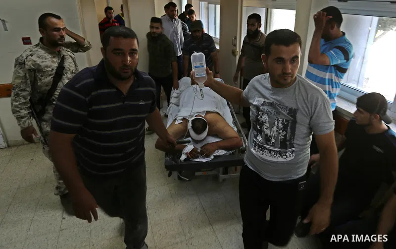 Mourners gather over the body of a Palestinian Abdul Karim Radwan who was killed in an Israeli air strike, at a hospital in Rafah in the southern of Gaza Strip July 19, 2018. Photo by Ashraf Amra