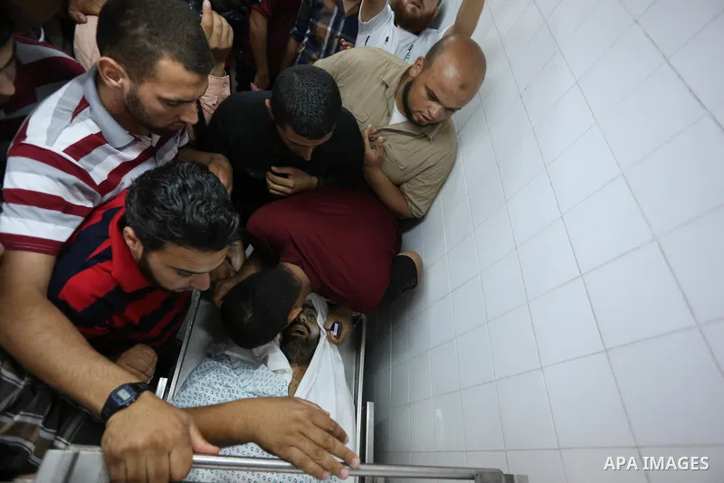 Relatives of Palestinian Abdul Karim Radwan, who was killed in an Israeli air strike, mourn over his body at a hospital in Rafah in the southern of Gaza Strip July 19, 2018. Photo by Ashraf Amra