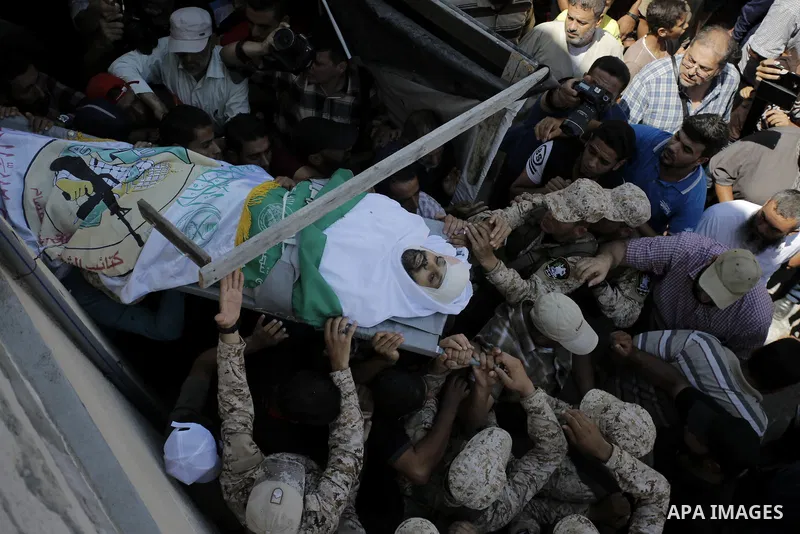 Mourners carry the body of Palestinian Abdul Karim Radwan, who was killed in an Israeli air strike, during his funeral in Rafah in the southern of Gaza Strip July 20, 2018. Photo by Ashraf Amra