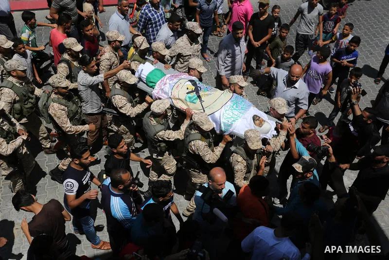 Mourners carry the body of Palestinian Abdul Karim Radwan, who was killed in an Israeli air strike, during his funeral in Rafah in the southern of Gaza Strip July 20, 2018. Photo by Ashraf Amra