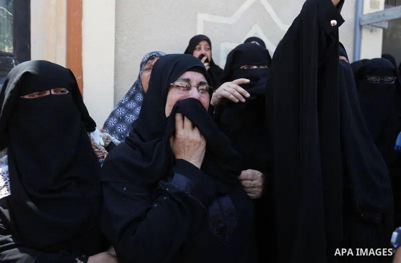 Relatives of Palestinian Abdul Karim Radwan, who was killed in an Israeli air strike, mourn during his funeral in Rafah in the southern of Gaza Strip on July 20, 2018. Photo by Ashraf Amra