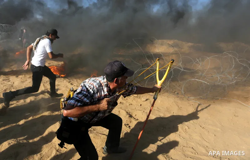 Palestinian protesters gather during clashes with Israeli troops in tents protest where Palestinian demand the right to return to their homeland at the Israel-Gaza border, in Khan Younis, in the southern Gaza Strip on Ju...