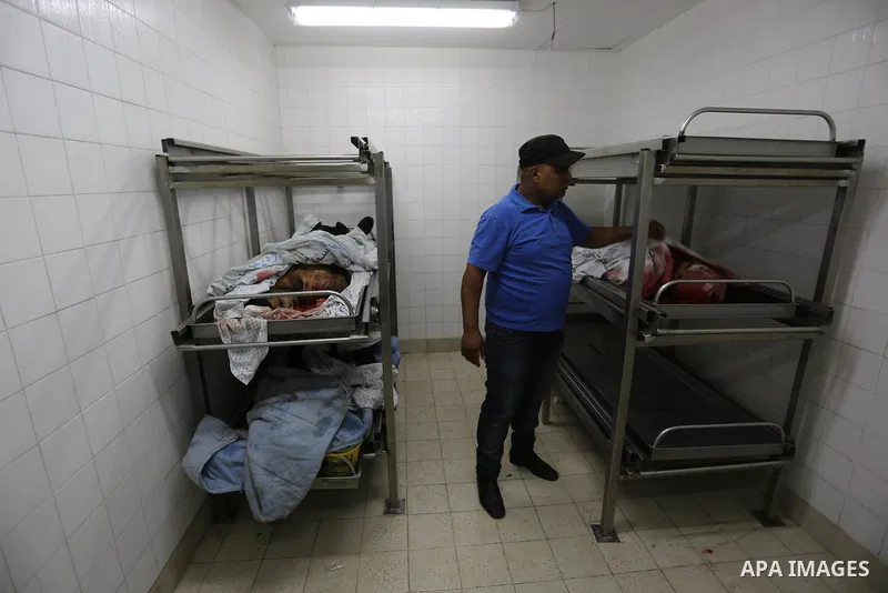 A Palestinian relative of Hamas members, who were killed by Israeli bombardment during clashes near the border with Israel, mourns over their bodies at a hospital in Khan Yunis in the southern Gaza Strip on July 20, 2018...