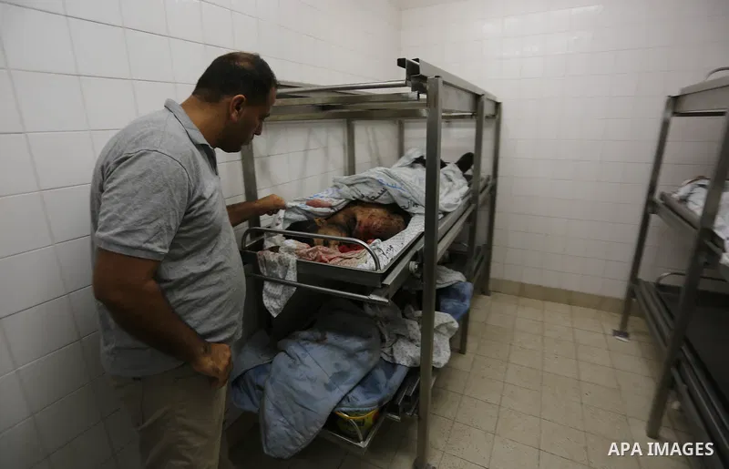 A Palestinian relative of Hamas members, who were killed by Israeli bombardment during clashes near the border with Israel, mourns over their bodies at a hospital in Khan Yunis in the southern Gaza Strip on July 20, 2018...