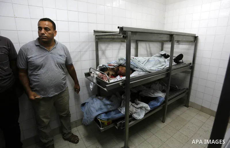 A Palestinian relative of Hamas members, who were killed by Israeli bombardment during clashes near the border with Israel, mourns over their bodies at a hospital in Khan Yunis in the southern Gaza Strip on July 20, 2018...