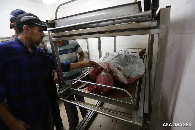 Palestinian relatives of Hamas members, who were killed by Israeli bombardment during clashes near the border with Israel, mourn over their bodies at a hospital in Khan Yunis in the southern Gaza Strip on July 20, 2018....