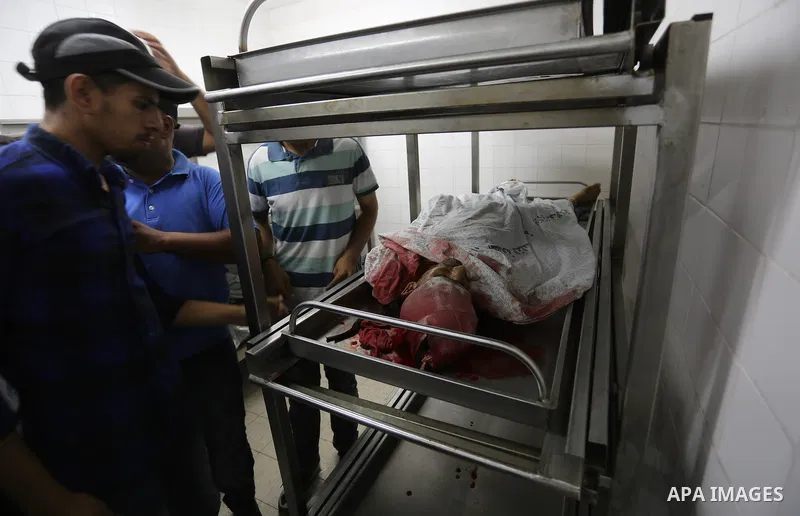 Palestinian relatives of Hamas members, who were killed by Israeli bombardment during clashes near the border with Israel, mourn over their bodies at a hospital in Khan Yunis in the southern Gaza Strip on July 20, 2018....