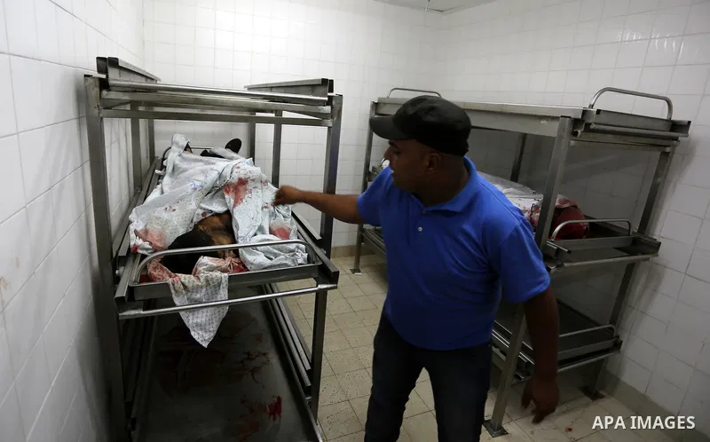 A Palestinian relative of Hamas members, who were killed by Israeli bombardment during clashes near the border with Israel, mourns over their bodies at a hospital in Khan Yunis in the southern Gaza Strip on July 20, 2018...