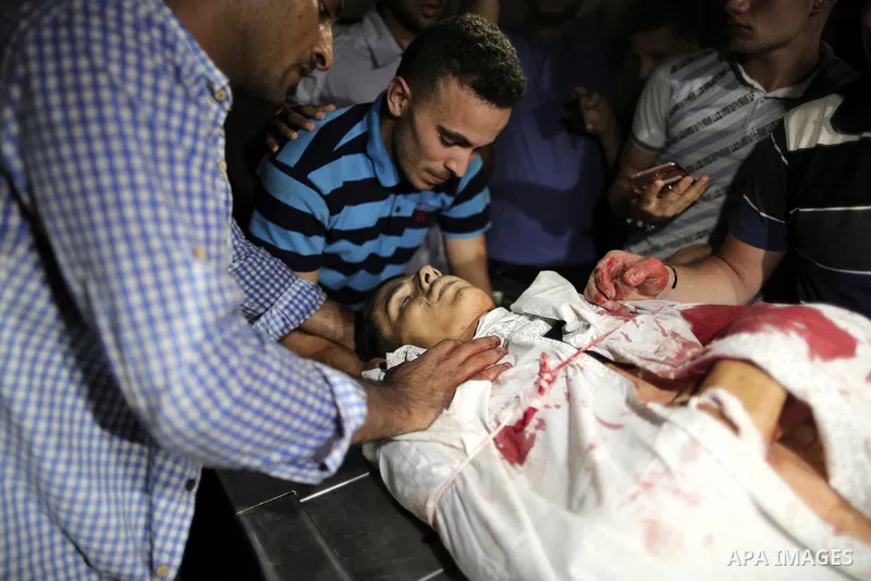 Relatives of Palestinian Mohammed Radwan, who was shot by Israeli forces during clashes at the Israel-Gaza border, mourn over his body at al-Shifa hospital in Gaza city on July 20, 2018. Photo by Mahmoud Ajour