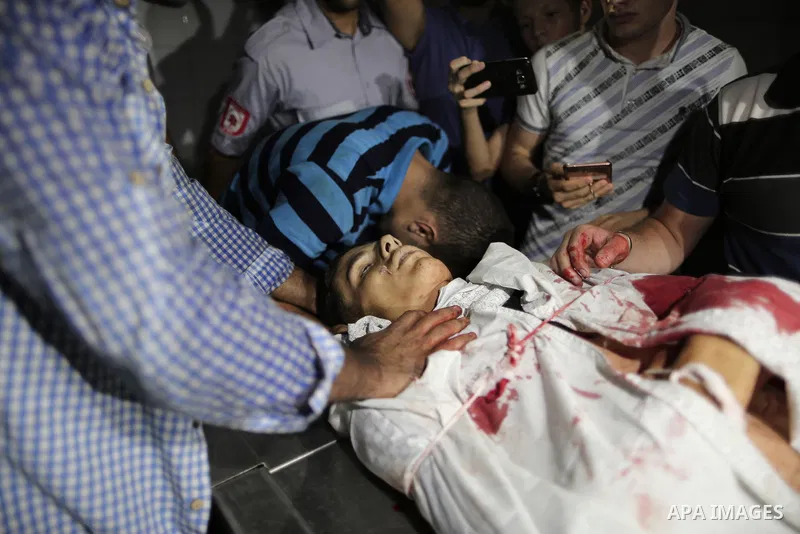 Relatives of Palestinian Mohammed Radwan, who was shot by Israeli forces during clashes at the Israel-Gaza border, mourn over his body at al-Shifa hospital in Gaza city on July 20, 2018. Photo by Mahmoud Ajour