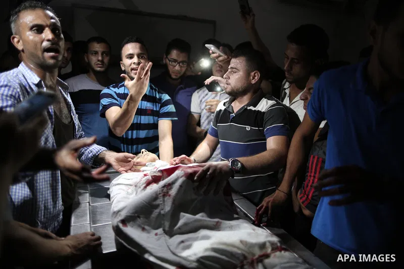 Relatives of Palestinian Mohammed Radwan, who was shot by Israeli forces during clashes at the Israel-Gaza border, mourn over his body at al-Shifa hospital in Gaza city on July 20, 2018. Photo by Mahmoud Ajour