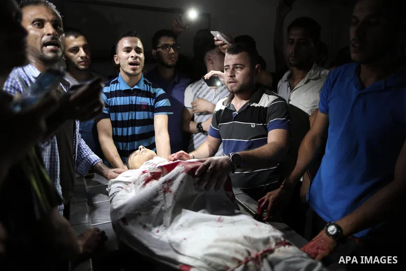 Relatives of Palestinian Mohammed Radwan, who was shot by Israeli forces during clashes at the Israel-Gaza border, mourn over his body at al-Shifa hospital in Gaza city on July 20, 2018. Photo by Mahmoud Ajour