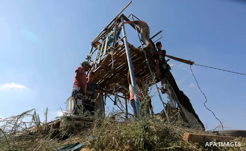 Palestinians inspect a military observation post damaged in an Israeli airstrike in Khan Younis in the southern of Gaza Strip, on July 21, 2018. Photo by Ashraf Amra