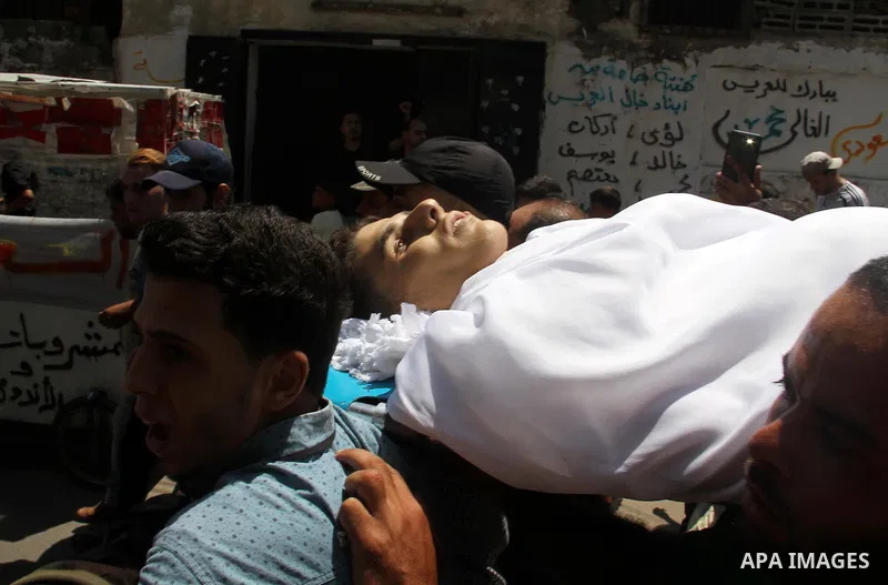 Mourners carry the body of Palestinian Mohammed Radwan, who was shot by Israeli forces during clashes at the Israel-Gaza border, during his funeral, in Gaza city on July 21, 2018. Photo by Mahmoud Ajour