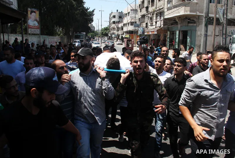 Mourners carry the body of Palestinian Mohammed Radwan, who was shot by Israeli forces during clashes at the Israel-Gaza border, during his funeral, in Gaza city on July 21, 2018. Photo by Mahmoud Ajour
