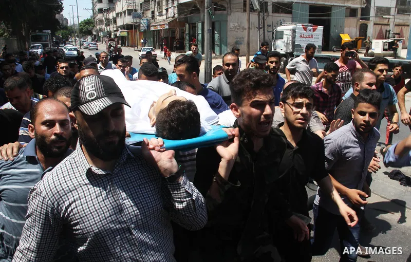 Mourners carry the body of Palestinian Mohammed Radwan, who was shot by Israeli forces during clashes at the Israel-Gaza border, during his funeral, in Gaza city on July 21, 2018. Photo by Mahmoud Ajour