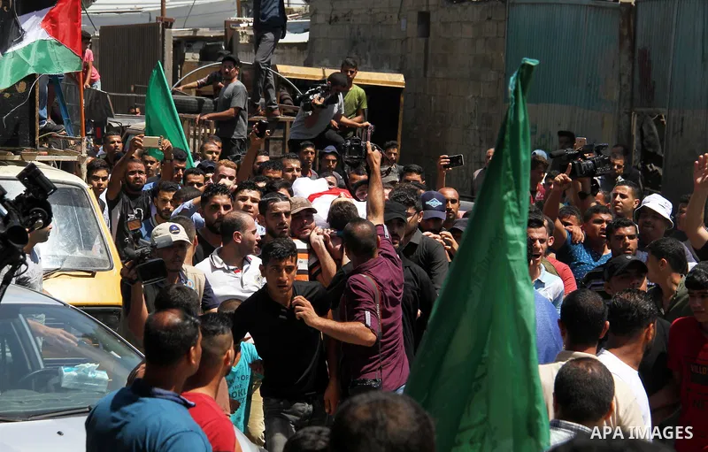 Mourners carry the body of Palestinian Mohammed Radwan, who was shot by Israeli forces during clashes at the Israel-Gaza border, during his funeral, in Gaza city on July 21, 2018. Photo by Mahmoud Ajour