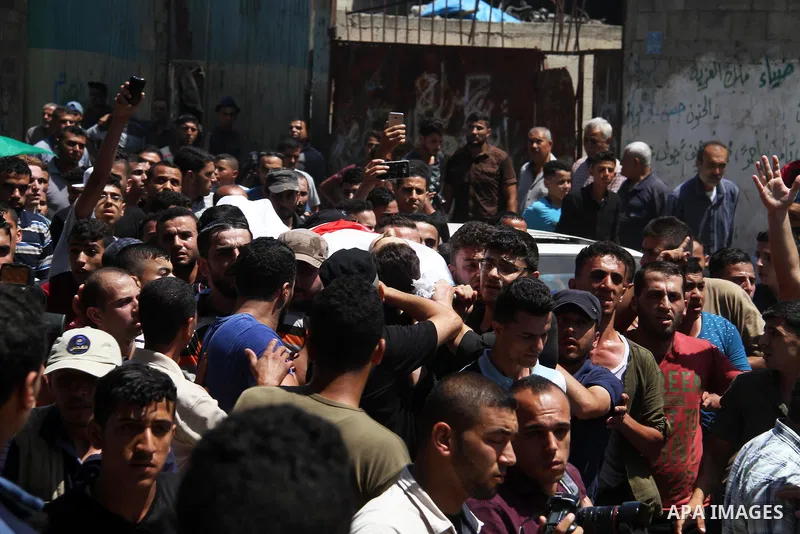 Mourners carry the body of Palestinian Mohammed Radwan, who was shot by Israeli forces during clashes at the Israel-Gaza border, during his funeral, in Gaza city on July 21, 2018. Photo by Mahmoud Ajour