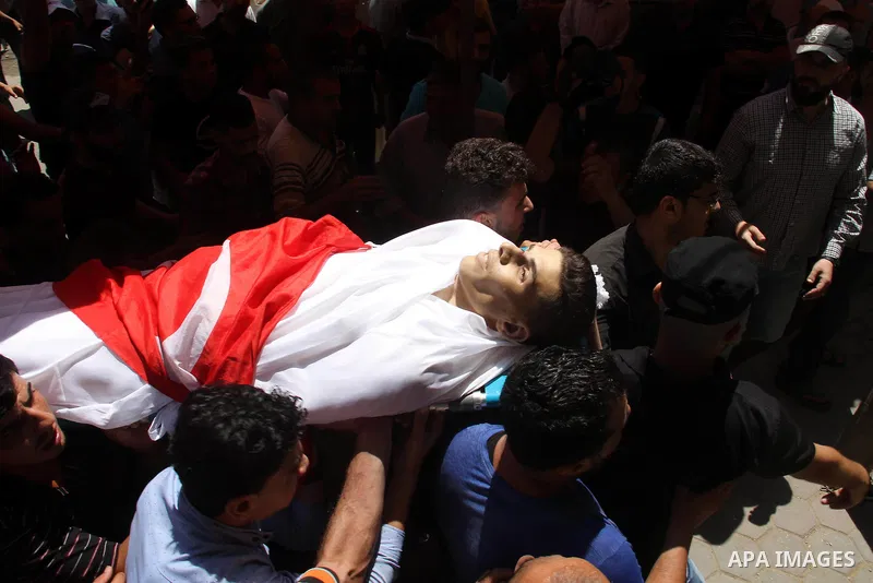 Mourners carry the body of Palestinian Mohammed Radwan, who was shot by Israeli forces during clashes at the Israel-Gaza border, during his funeral, in Gaza city on July 21, 2018. Photo by Mahmoud Ajour