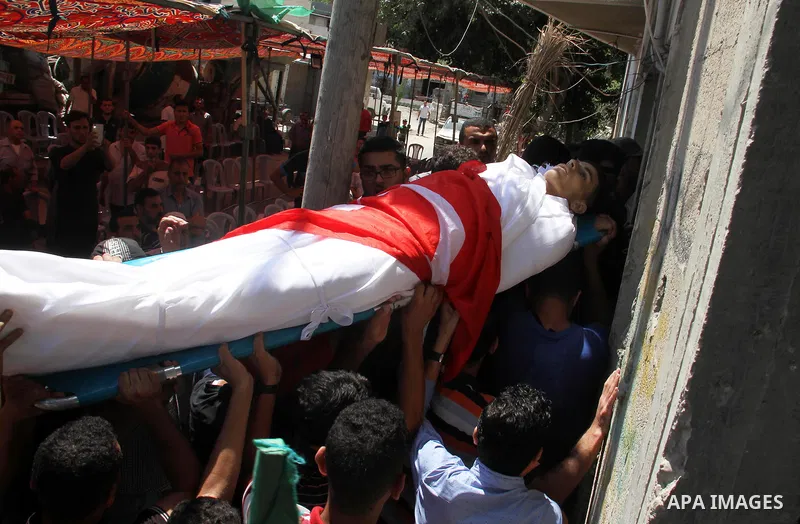 Mourners carry the body of Palestinian Mohammed Radwan, who was shot by Israeli forces during clashes at the Israel-Gaza border, during his funeral, in Gaza city on July 21, 2018. Photo by Mahmoud Ajour