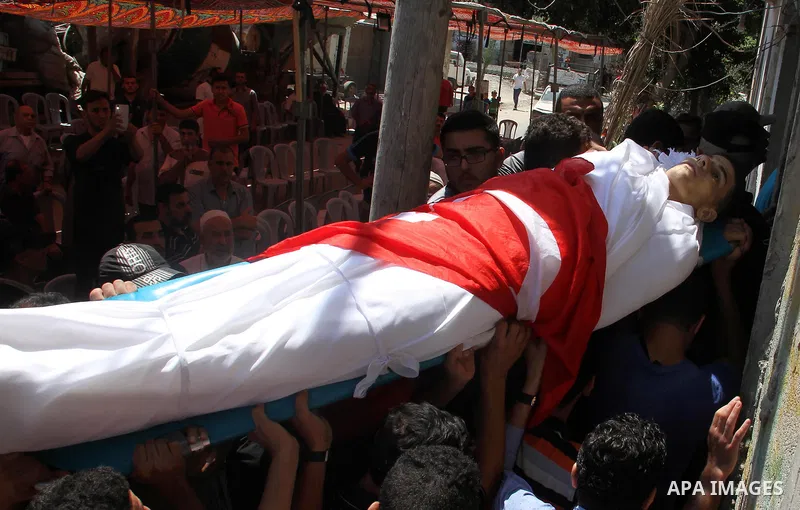 Mourners carry the body of Palestinian Mohammed Radwan, who was shot by Israeli forces during clashes at the Israel-Gaza border, during his funeral, in Gaza city on July 21, 2018. Photo by Mahmoud Ajour