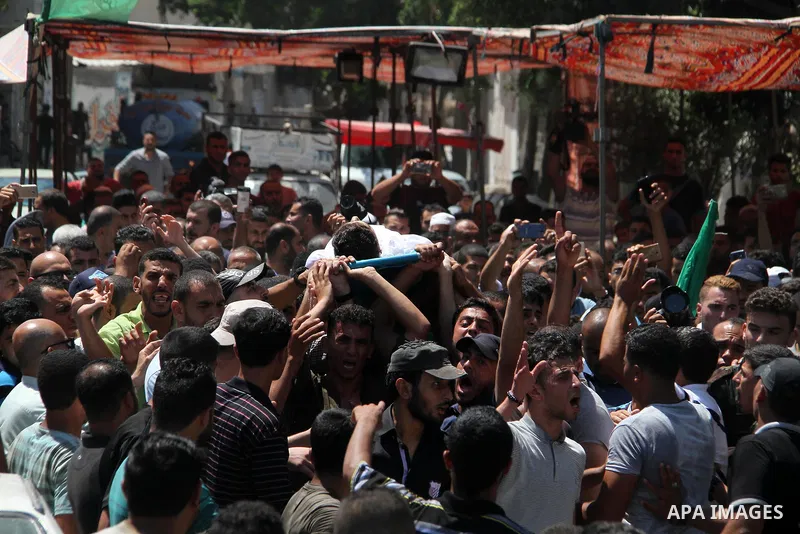 Mourners carry the body of Palestinian Mohammed Radwan, who was shot by Israeli forces during clashes at the Israel-Gaza border, during his funeral, in Gaza city on July 21, 2018. Photo by Mahmoud Ajour