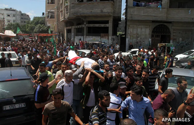 Mourners carry the body of Palestinian Mohammed Radwan, who was shot by Israeli forces during clashes at the Israel-Gaza border, during his funeral, in Gaza city on July 21, 2018. Photo by Mahmoud Ajour