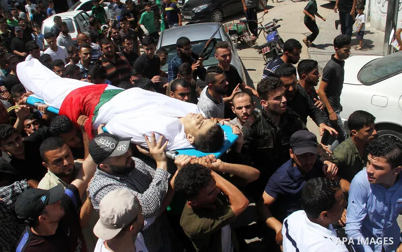 Mourners carry the body of Palestinian Mohammed Radwan, who was shot by Israeli forces during clashes at the Israel-Gaza border, during his funeral, in Gaza city on July 21, 2018. Photo by Mahmoud Ajour