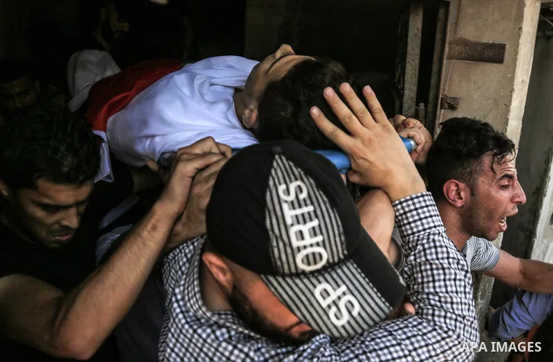 Mourners carry the body of Palestinian Mohammed Radwan, who was shot by Israeli forces during clashes at the Israel-Gaza border, during his funeral, in Gaza city on July 21, 2018. Photo by Dawoud Abo Alkas