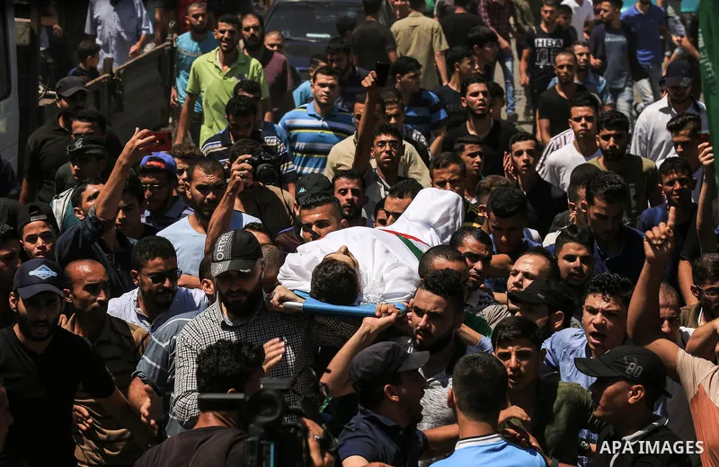 Mourners carry the body of Palestinian Mohammed Radwan, who was shot by Israeli forces during clashes at the Israel-Gaza border, during his funeral, in Gaza city on July 21, 2018. Photo by Dawoud Abo Alkas