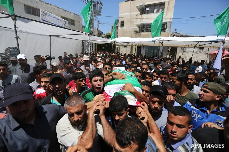 Mourners carry the body of Palestinian militant Mohammed Abu Dakah, 31, who was killed in an Israeli strike, during his funeral in Khan Younis in the southern of Gaza Strip, on July 21, 2018. Photo by Ashraf Amra
