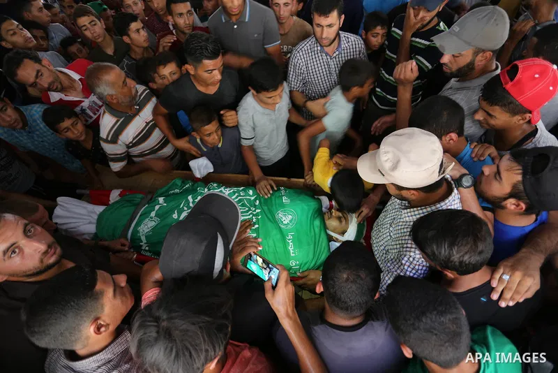 Relatives of Palestinian militant Shaaban Abu Khater, 31, who was killed in an Israeli strike, mourn over his body during his funeral in Khan Younis in the southern of Gaza Strip, on July 21, 2018. Photo by Ashraf Amra