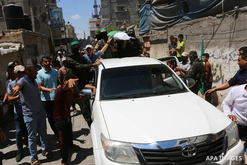 Members of Ezzedine al-Qassam Brigades, the armed wing of the Palestinian Hamas movement, carry the body of their comrade Mahmoud Qeshta, who was killed in an Israeli strike,during his funeral in Rafah in the southern of...
