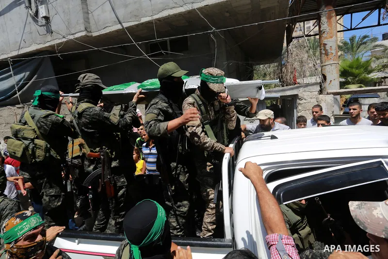 Members of Ezzedine al-Qassam Brigades, the armed wing of the Palestinian Hamas movement, carry the body of their comrade Mahmoud Qeshta, who was killed in an Israeli strike,during his funeral in Rafah in the southern of...