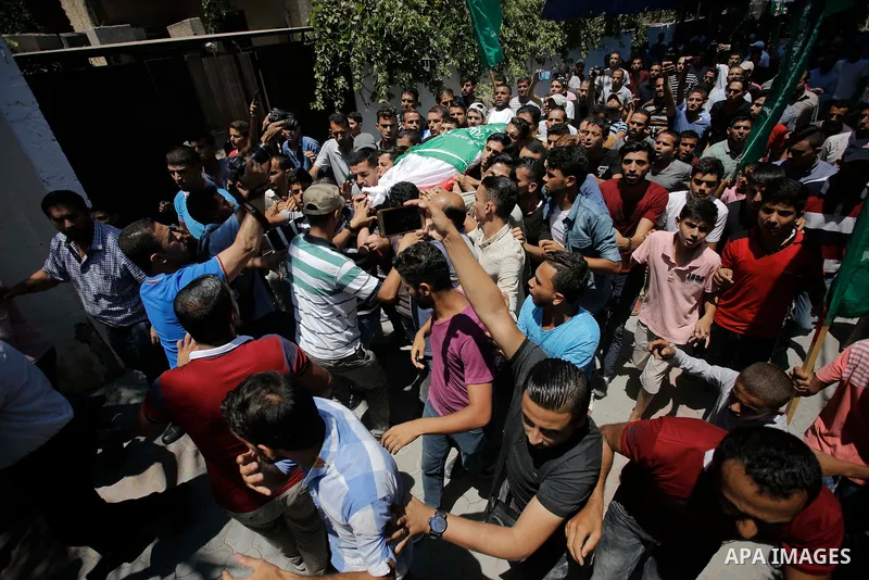 Palestinian mourners carry the body of Ezzedine al-Qassam miltant, Mohammed Abu Daqqa, who was killed in an Israeli strike, during his funeral in Khan Younis in the southern of Gaza Strip, on 21 Jul 2018. Israel air stri...