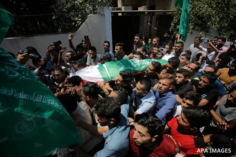 Palestinian mourners carry the body of Ezzedine al-Qassam miltant, Mohammed Abu Daqqa, who was killed in an Israeli strike, during his funeral in Khan Younis in the southern of Gaza Strip, on 21 Jul 2018. Israel air stri...