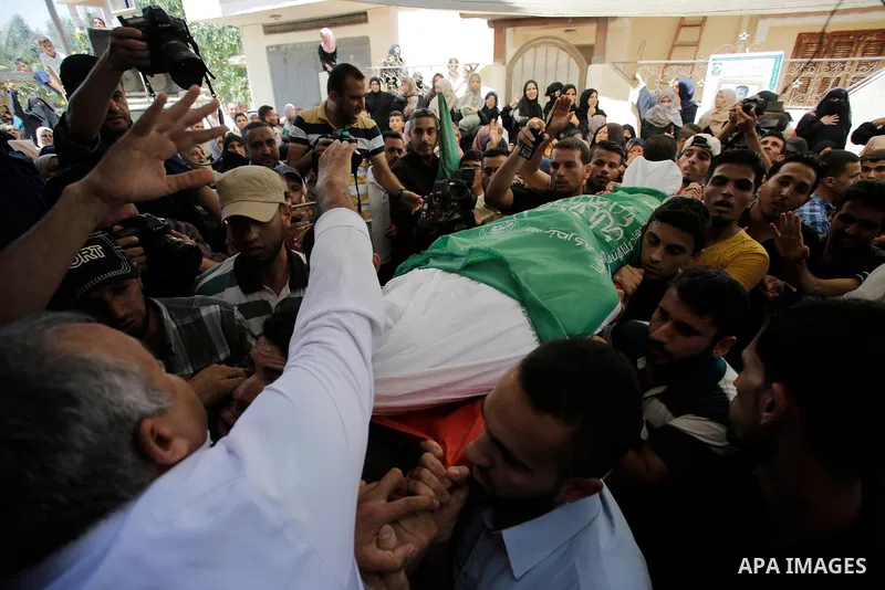 Palestinian mourners carry the body of Ezzedine al-Qassam miltant, Mohammed Abu Daqqa, who was killed in an Israeli strike, during his funeral in Khan Younis in the southern of Gaza Strip, on 21 Jul 2018. Israel air stri...