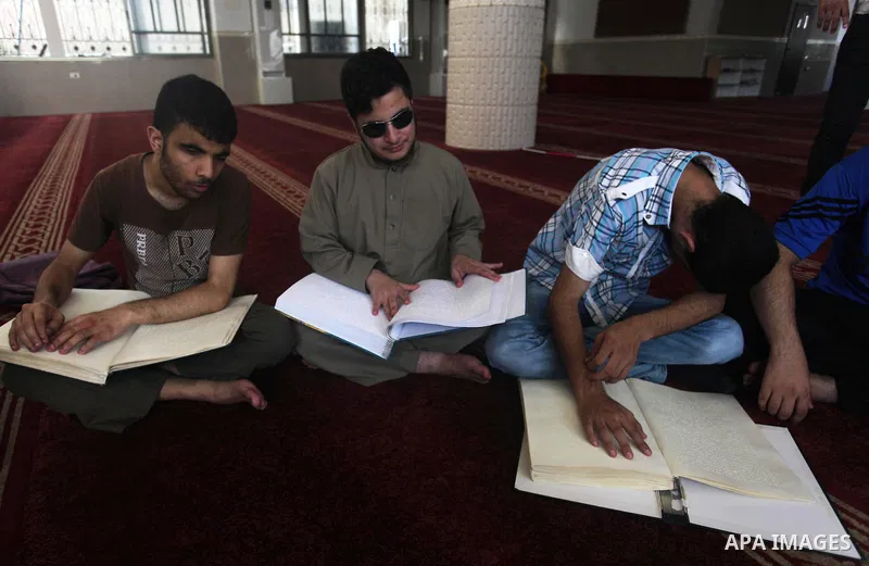 Palestinian blind boys read and memorise the holy Quran in braille at Dar al-Quran and Sunnah in Gaza city, on July 23, 2018. Photo by Mahmoud Ajour