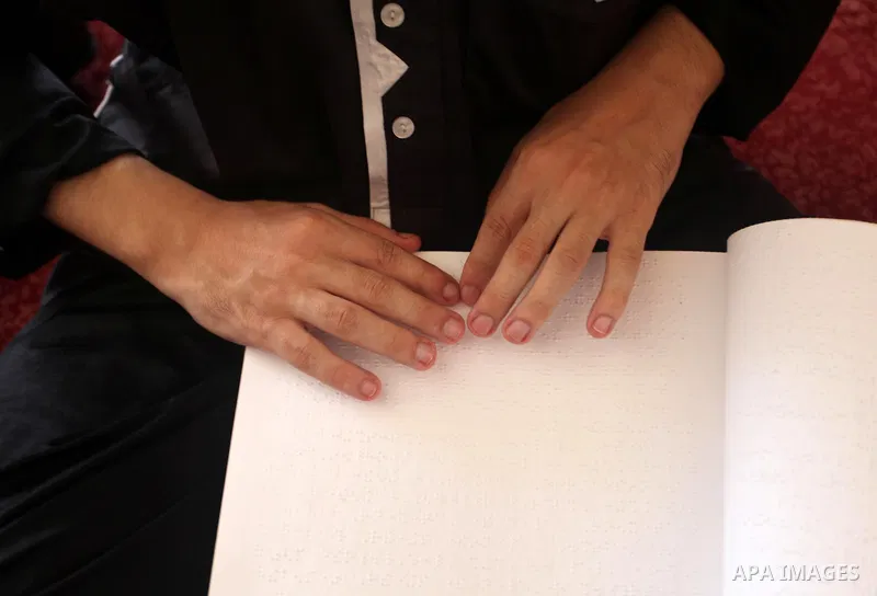 A Palestinian blind boy reads and memorise the holy Quran in braille at Dar al-Quran and Sunnah in Gaza city, on July 23, 2018. Photo by Mahmoud Ajour