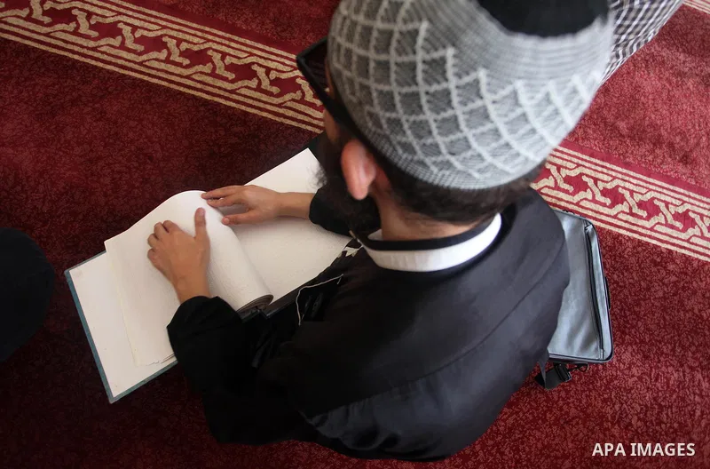 A Palestinian blind boy reads and memorise the holy Quran in braille at Dar al-Quran and Sunnah in Gaza city, on July 23, 2018. Photo by Mahmoud Ajour