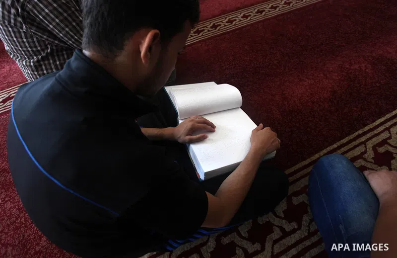 A Palestinian blind boy reads and memorise the holy Quran in braille at Dar al-Quran and Sunnah in Gaza city, on July 23, 2018. Photo by Mahmoud Ajour