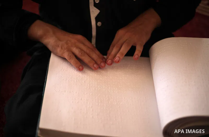 A Palestinian blind boy reads and memorise the holy Quran in braille at Dar al-Quran and Sunnah in Gaza city, on July 23, 2018. Photo by Mahmoud Ajour