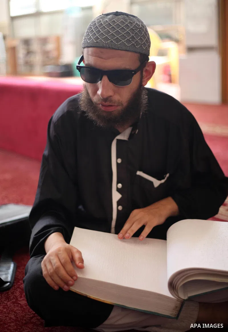 A Palestinian blind boy reads and memorise the holy Quran in braille at Dar al-Quran and Sunnah in Gaza city, on July 23, 2018. Photo by Mahmoud Ajour