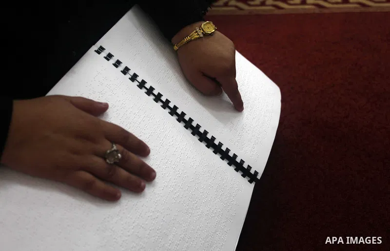 A Palestinian blind girl reads and memorise the holy Quran in braille at Dar al-Quran and Sunnah in Gaza city, on July 23, 2018. Photo by Mahmoud Ajour